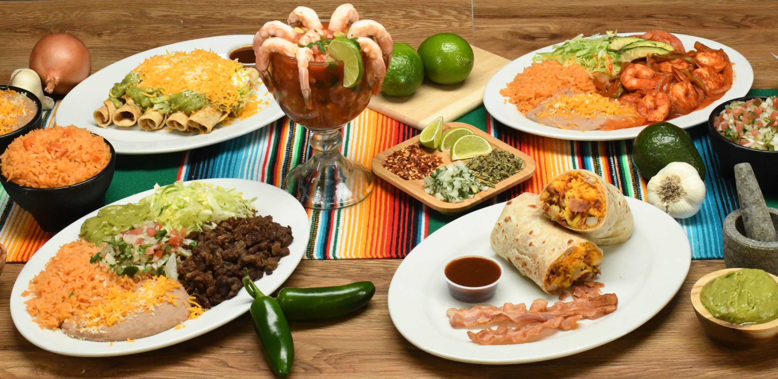 Table setting with several plates filled with Roberto's Taco Shop combos, entrees, and appetizers